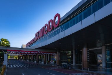 Labuan Bajo, Endonezya, 9 Ekim 2024 Komodo Uluslararası Havalimanı 'nın büyüleyici bir görüntüsü, açık mavi gökyüzünün arka planına karşı modern mimarisini ve canlı tabelalarını sergiliyor.