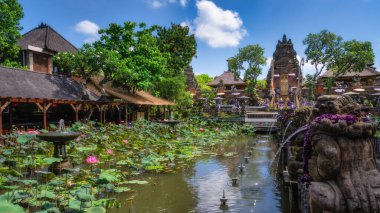 Bali, Endonezya, 10 Ekim 2024 sakin ve pitoresk bir Balili Ubud Su Sarayı bahçesinde büyüleyici nilüfer havuzu geleneksel yapıları ve parlak mavi gökyüzünün altında yemyeşil alanları keşfedebilirsiniz.