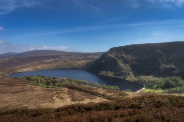Berrak, berrak bir gökyüzünün altında yuvarlanan tepeler arasında güzelce yuva yapmış sakin, sakin bir gölün nefes kesici manzarası doğanın, Wicklow 'un, İrlanda' nın güzelliğini görkemli bir şekilde gözler önüne seriyor.