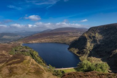 Nefes kesen manzara, berrak ve çarpıcı mavi gökyüzü altında, Bereketli yeşil tepeler arasında güzelce yuva yapmış sakin ve sakin bir Bray gölü içerir, Wicklow, İrlanda