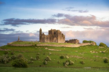 Cashel Kayası 'nın eski harabelerinin çarpıcı manzarası yemyeşil bir tepenin üzerinde, resim gibi bir gökyüzünün altında seyahat ve tarih meraklıları için ideal, Tipperary, İrlanda