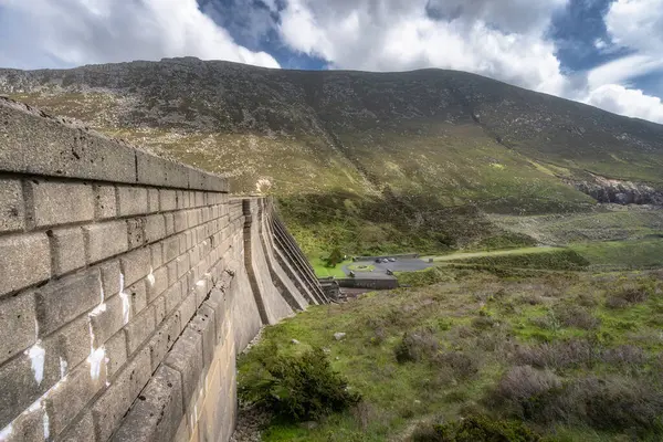 İkonik Sessiz Vadi Barajı 'nın çarpıcı manzarası, Kuzey İrlanda' nın yenilikçi mühendisliği ve doğa arasındaki ahengi gözler önüne seren Yas Dağları 'nın yemyeşil tepeleriyle çok güzel tezat oluşturuyor.