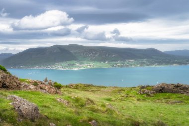 Çarpıcı bir kıyı manzarasının nefes kesici manzarası canlı yeşillikler, sakin sular ve izleyiciyi büyüleyen güzel bulutlu bir gökyüzü, Carlingford, İrlanda