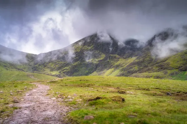 Bereketli bir dağ manzarasının büyüleyici güzelliğini deneyimleyin canlı yeşillik ve büyüleyici bulutlar, doğa severler ve macera arayanlar için mükemmel, Kerry, İrlanda