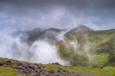 Tamamen canlı ve gür yeşillikle kaplanmış muhteşem, sisli Carrauntoohil dağının nefes kesici ve çarpıcı manzarası, sakin bir atmosfer yaratıyor, Kerry, İrlanda