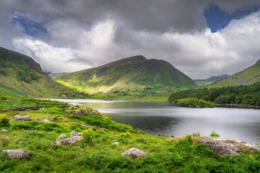 Göz kamaştırıcı bir dağ manzarası güzel, sakin bir göl, gür, canlı bir Kara Vadi yeşilliği ve etkileyici bulutları barındırıyor, doğanın nefes kesici güzelliğini gözler önüne seriyor, Kerry, İrlanda