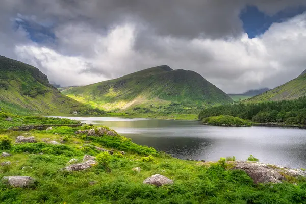 Göz kamaştırıcı bir dağ manzarası güzel, sakin bir göl, gür, canlı bir Kara Vadi yeşilliği ve etkileyici bulutları barındırıyor, doğanın nefes kesici güzelliğini gözler önüne seriyor, Kerry, İrlanda