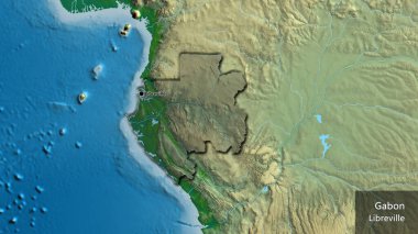 Gabon sınır bölgesinin yakın çekimleri fiziksel bir harita üzerinde koyu bir örtüyle vurgulanıyor. Ana nokta. Kırsal kesimin kıvrımlı kenarları. Ülkenin ve başkentinin İngilizce adı