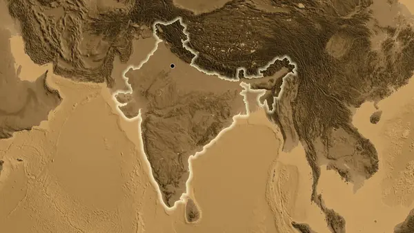 Close-up of the India border area on a sepia elevation map. Capital point. Glow around the country shape.