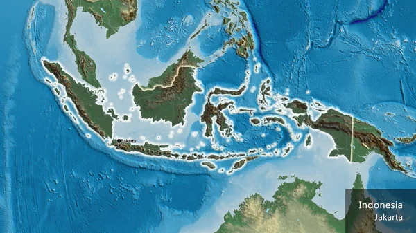 救援地図上の暗いオーバーレイで強調されているインドネシア国境地域のクローズアップ 資本ポイント 国の形の周りに光る 英名国とその首都 — ストック写真