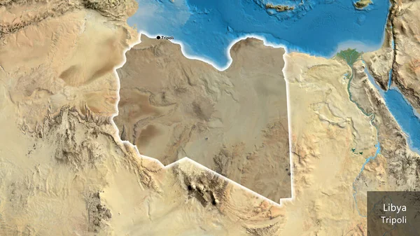 stock image Close-up of the Libya border area highlighting with a dark overlay on a satellite map. Capital point. Glow around the country shape. English name of the country and its capital