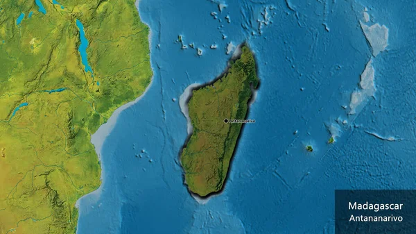 stock image Close-up of the Madagascar border area highlighting with a dark overlay on a topographic map. Capital point. Bevelled edges of the country shape. English name of the country and its capital