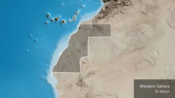 Close-up of the Western Sahara border area highlighting with a dark overlay on a satellite map. Capital point. Outline around the country shape. English name of the country and its capital