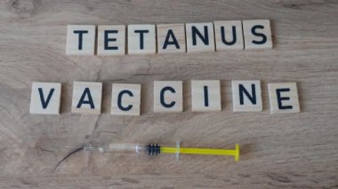 Tetanos aşısı konsepti. Eldivenli el şırınga alıyor..