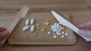 Yemek. Tabak dolusu vitamin ya da ilaç. Aşırı kullanım (suiistimal) ve diyet takviyeleri kavramı.