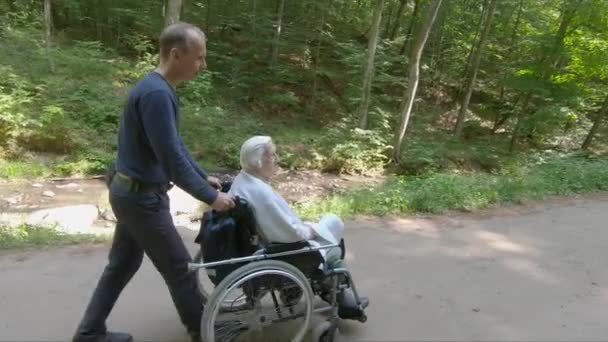 Άντρας Και Γριά Αναπηρικό Καροτσάκι Κατά Διάρκεια Του Περιπάτου Στο — Αρχείο Βίντεο