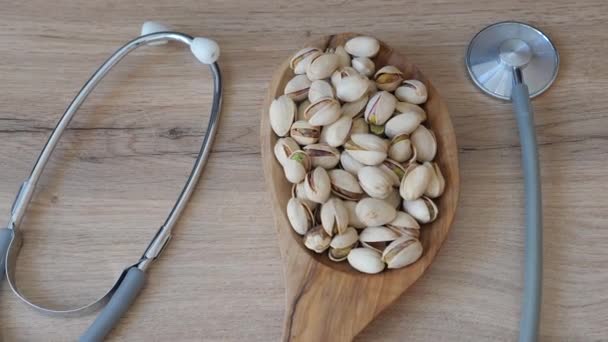 Acercarse Los Pistachos Plato Madera Junto Estetoscopio Médico Snacks Saludables — Vídeos de Stock