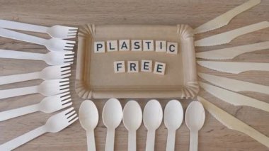 Piknik ahşap çatal bıçaklarla çevrili kağıt tepsinin üzerindeki PLASTIC özgür kelimelerini yakınlaştır.