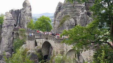 BASTEI, ALMANY - 15 Ağustos 2015: Bastei uçurumları ve bir köprüdeki turistler. Sakson İsviçre Ulusal Parkı, Almanya