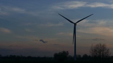 Akşam karanlığında rüzgar türbininin silueti