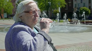 Kadın kıdemli içecekler su sıcak yaz gününde