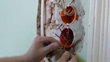 Elektrikçi elektrik prizine yeni kablolar kuruyor