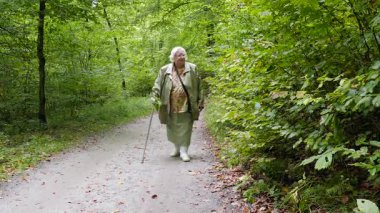 Yaşlı kadın bir baston parkta bir yürüyüş ile