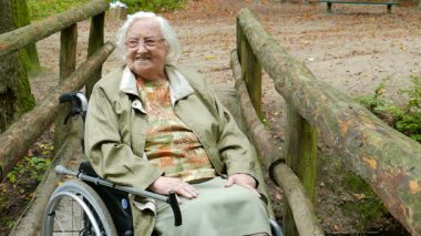 Tekerlekli sandalyedeki kıdemli kadın orman manzarasının keyfini çıkarıyor