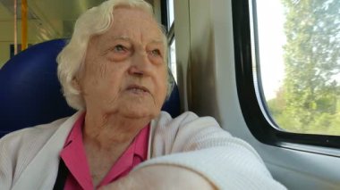Kadın kıdemli bir tren penceresinde bakar