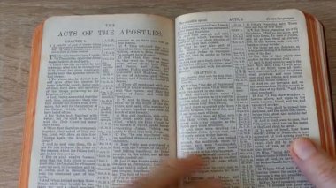 Eller eski 1899 Kral James İncilinin sayfalarını çeviriyor.