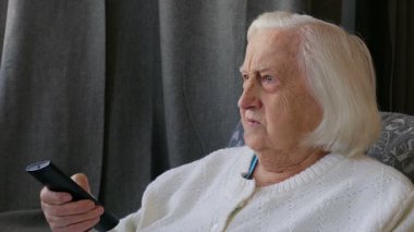 Yaşlı, kıdemli kadın evde televizyon izliyor. Yakın çekim 