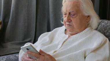 Yaşlı kadın akıllı telefon kullanıyor