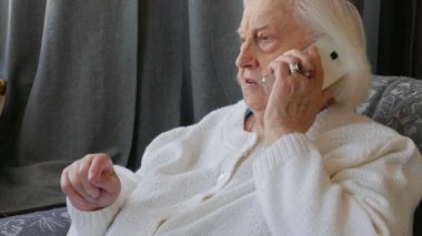 Yaşlı kadın akıllı telefonla konuşuyor