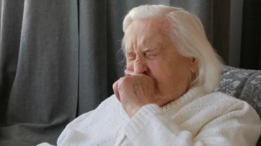 Yaşlı kadın burnunu okşuyor.