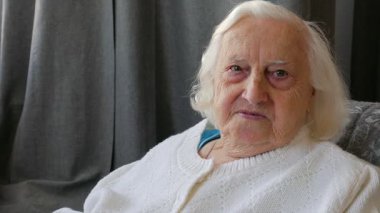 Kameraya gülümseyen yaşlı bir kadın portresi