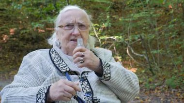 İçme suyu ya da alkol komik yaşlı bir kadın tekerlekli sandalyede olduğunu