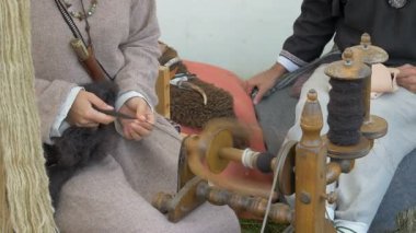 Kadın yün örüyor. Dönen tekerlek