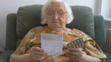 Yaşlı bir kadın bir tıp broşür okur