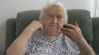 Kıdemli kadın saç modeli düzeltir ve boncuk koyar