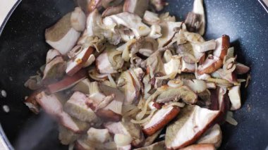 Kızartma tavasında soğanlı Porcini mantarı (boletus edulis).