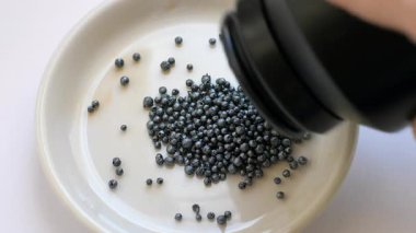 Beyaz tabağa iyot kristalleri (granüller) dökülüyor