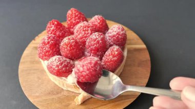 Kırmızı ahududulu tart yiyorum.