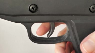 Silahın içinde tetiği çekmek. Beyaz arkaplan