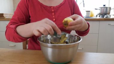 Kadın patates soyuyor.