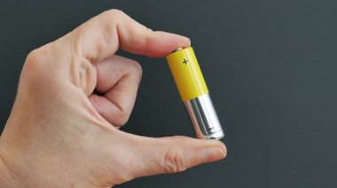 Eli bataryayı tutuyor. Geri dönüşüm veya enerji enerjisi kavramı