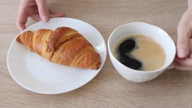 Masadan kahve ve kruvasan alıyorum.