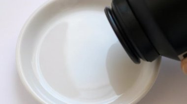 Beyaz tabağa iyot kristalleri (granüller) dökülüyor