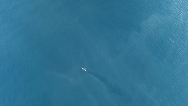 小さなボートがクリスタルブルーの水の上を帆走する エアロビュー フィリピン フットボール — ストック動画