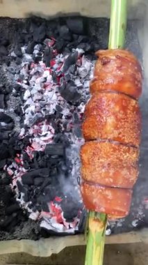 Lechon göbeğini geleneksel şekilde kızartıyorum. Bambu tükürüğünün üzerine bir parça domuz eti.. 