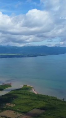 Deniz kıyısı manzarası, dağlar, deniz ve bulutlar mavi gökyüzünde. 